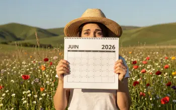 Une agricultrice dans une prairie fleurie tient un calendrier ouvert sur le mois de juin 2026 qui annonce les aides de la PAC